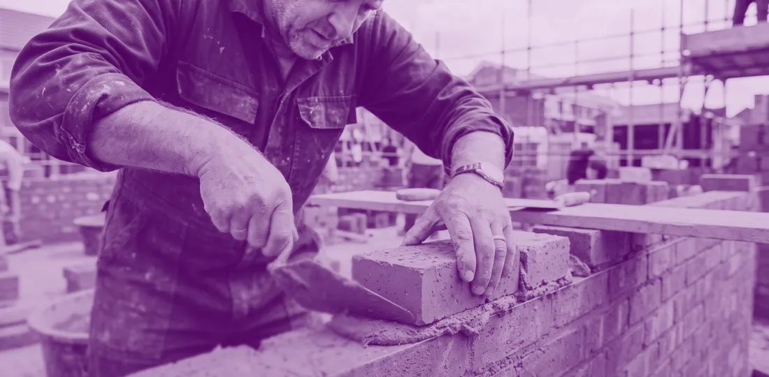 Bricklayer building walls on a construction site